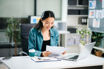  Beautiful Asian business woman typing laptop and tablet Placed at the table at the office