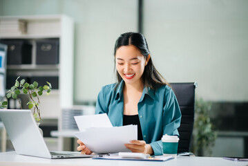 Cheerful businesswoman checking time feeling motivated waiting for leaving office do on their tablet, laptop and taking notes