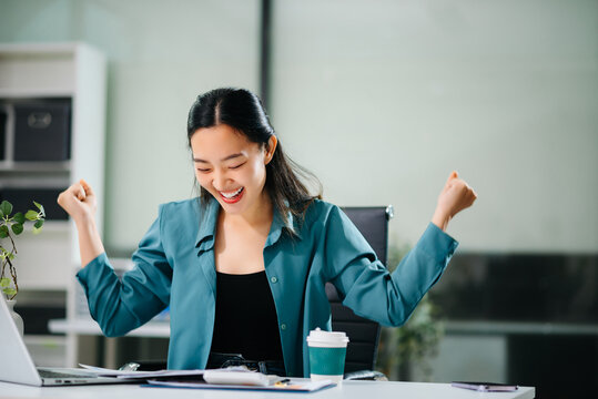 Cheerful businesswoman checking time feeling motivated waiting for leaving office do on their tablet, laptop and taking notes
