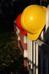 yellow helmet on a metal fence