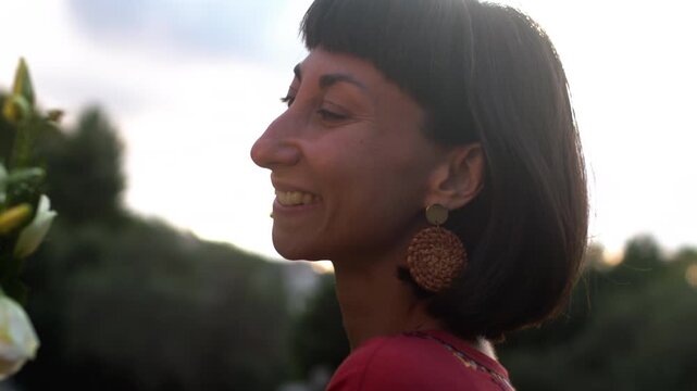 A girl is given a bouquet of flowers. A close-up portrait of a young, attractive, smiling woman with a huge bouquet of flowers standing outside on a sunny autumn day. Valentine's Day. First date.