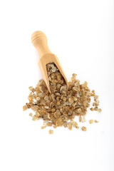 Pearl millet flakes spilled out of scoop on white background