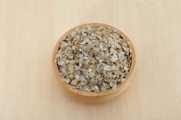 Pearl millet flakes in wooden bowl,close up