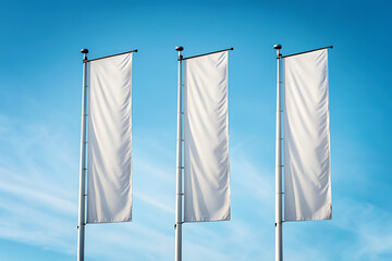Three vertical white flags waving against a clear blue sky