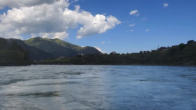 A motorboat ride along mountain river. Slow motion of speedboating on Altai river Katun in rainy day