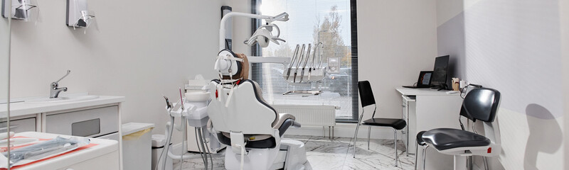 Empty modern dental office showing dental chair and equipment prepared for patients attending...