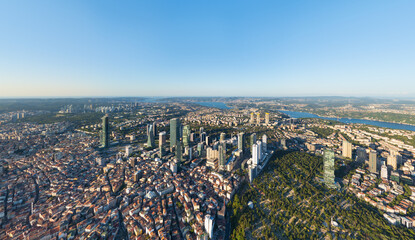 Istanbul, Turkey. Panoramic aerial drone view of European part city skyline with modern skyscrapers and Bosphorus Strait at sunset, clear sky. Aerial view