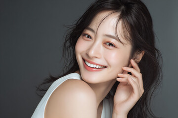 Fototapeta premium 笑顔できらめく綺麗な肌と白い歯を見せる日本人女性美人モデルの接写写真。デンタルケア, オーラルケア、スキンケア、コスメ広告用。