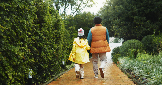 Back, outdoor or father with daughter on path for holiday, connection or holding hands for support. Care, travel trip or man walking with child for bonding, winter vacation or explore park together - Powered by Adobe