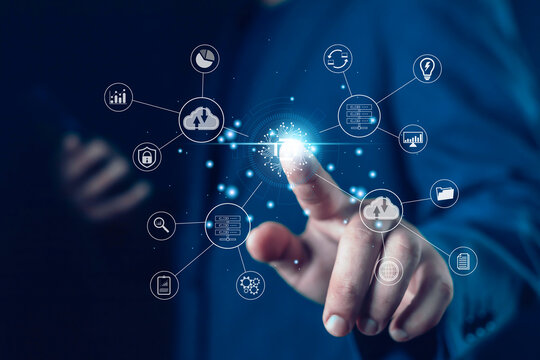 A business hand touching a glowing digital interface with cloud computing, AI, data analytics, and cybersecurity icons, representing modern technology, smart systems, innovation, and connected digital