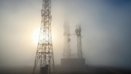 Ethereal Towers: Communication infrastructure piercing through heavy fog, a visual metaphor for - Powered by Adobe