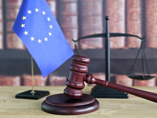 European Union legal concept with gavel, flag, and scales of justice in a courtroom