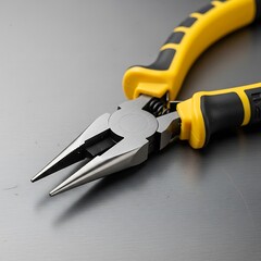 Precision instrument needle nose pliers with insulated grip on gray background