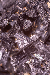 Tourmaline black crystals. Gems. Mineral crystals in the natural environment. Texture of precious and semiprecious stones. Seamless background with copy space colored shiny surface of precious stones.