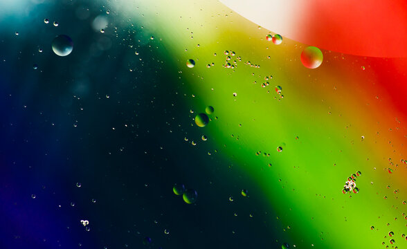 Vibrant abstract background with colorful diagonal stripes of blue green yellow and red with water droplets