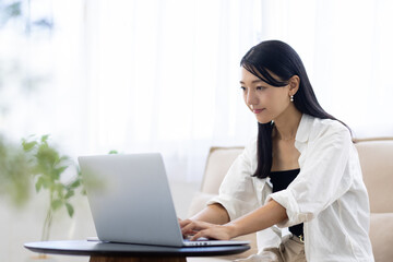 Young Woman Working from Home While Talking on Smartphone