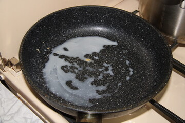a frying pan with grease on the stove,