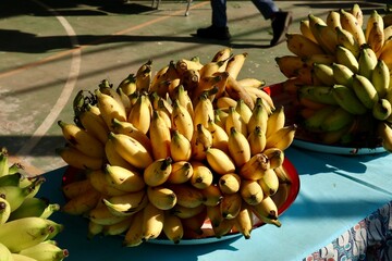yellow and green asian bananas on banana leaves and blurry background
