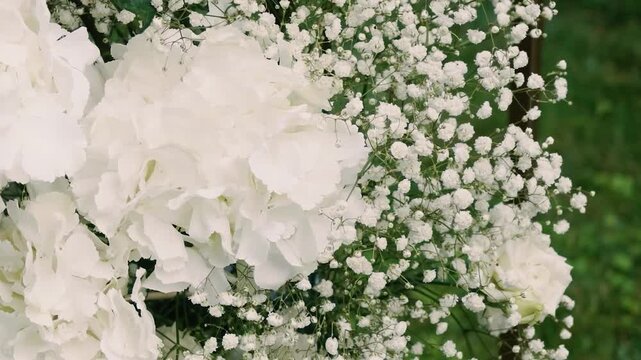 Beautiful white roses and eustoma flowers with petals and a romantic atmosphere. Outdoor wedding ceremony for the bride and groom. Decor and floristry.