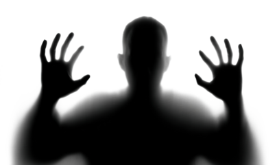 Scary silhouette of person with hands against surface, isolated on transparent cutout background