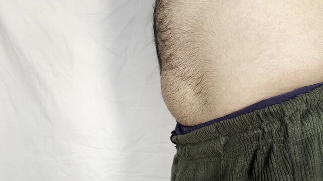 fat man breathing in and out and showing his fat belly, obese man. Man showing his belly fat signs of obesity.
