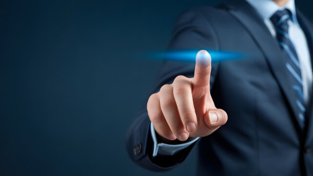 Close-up photograph of businessman’s hand in dark blue suit sleeve touching virtual interface concept of innovation leadership and digital business