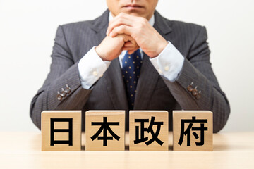 「日本政府」と書かれたブロックとビジネスマン