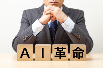 「AI革命」と書かれたブロックとビジネスマン