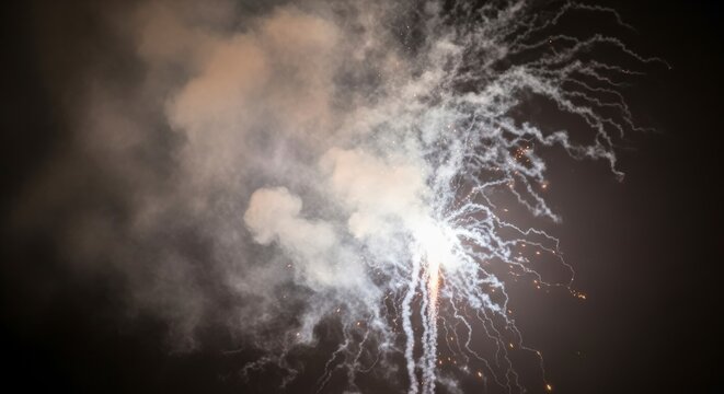 Bright white light trails and smoke from a firework illuminating the dark night sky - Powered by Adobe