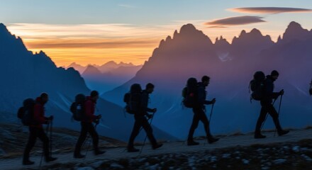 Obraz premium Team of Backpackers Walking Through Mountain Landscape at Dusk