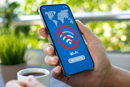 man hand holds phone with Wi-Fi banned on screen cafe - Powered by Adobe