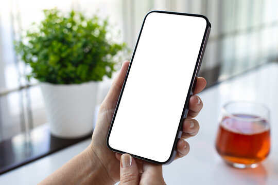 Female hand holding phone with isolated screen glass of juice