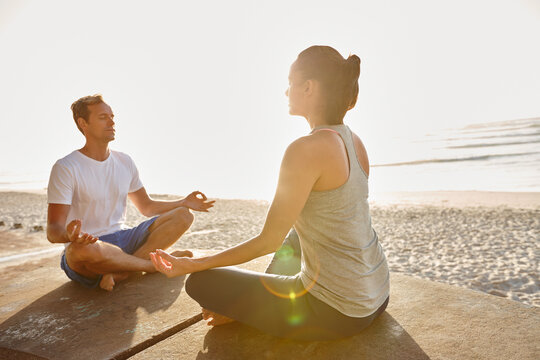 Fitness, meditation and yoga with couple on beach together for holistic health or wellness. Lotus pose, balance and flare with yogi people outdoor for exercise, inner peace or mindfulness routine