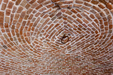 Fototapeta premium Brick vaulted ceiling of a historical ice pit in Bratislava, showing circular brick pattern and old metal ring detail.
