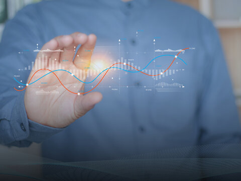 Experts are interacting with holographic financial charts that represent data analysis, business growth, investment planning, profit, returns and marketing strategies, risk exposure.