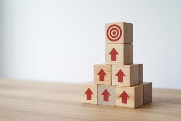 Wooden blocks stacked in a pyramid structure represent progressive steps toward achieving a clear objective