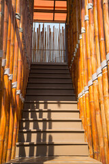 Stair with bamboo decorated wall and handrail for hold on to wood to go up and down.