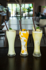 Fruit smoothies in the glasses that make from  Pineapple, Kiwi and mango. Taken from eye level, the drinks evoke a serene, tropical setting at the Juice Bar restaurant.