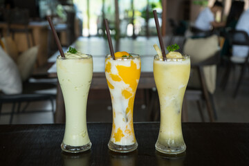 Fruit smoothies in the glasses that make from  Pineapple, Kiwi and mango. Taken from eye level, the drinks evoke a serene, tropical setting at the Juice Bar restaurant.
