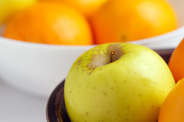 Assortment of fruits in two kitchen bowls. Apples with citrus.