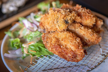 crispy fried chicken wings served with fresh salad on a plate