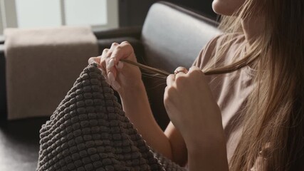 Tilt up shot of young woman fidgeting her hair coping with anxious thoughts while sharing her story during therapy session