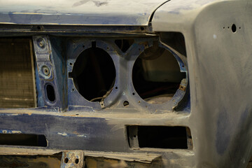The metal skeleton of the car body in the headlight area
