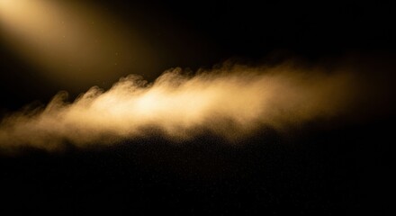 Golden dust cloud with glowing particles illuminated by a dramatic beam of light on a dark black background, creating a magical and mysterious abstract texture