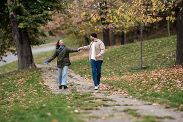 Happy couple walking autumn park enjoying love and romance