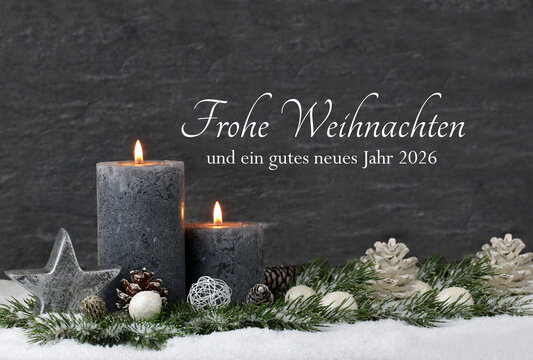 Weihnachtskarte: Graue Kerzen mit Weihnachtskugeln und Tannenzweige die im Schnee liegen mit der Beschriftung Frohe Weihnachten und ein gutes neues Jahr 2026.