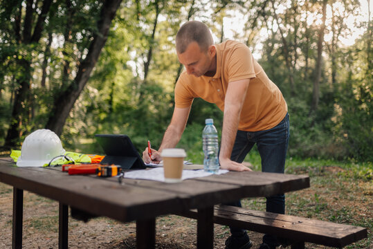 Engineer working with tablet and blueprint in a park - Powered by Adobe