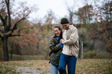 Happy multicultural couple walking in autumn park