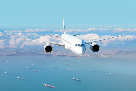 Fototapeta Passenger airplane landing to airport -Airplane taking off from Changi Airport - Passenger airplane is flying over amazing sea - Commercial Tankers and container ships wait in the Straits of Singapore