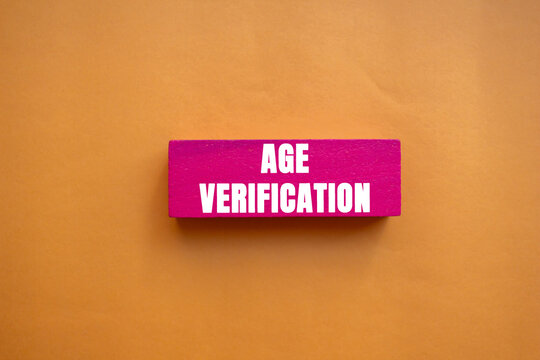 Age Verification message written on pink wooden block on orange background. Conceptual Age Verification symbol. Copy space.